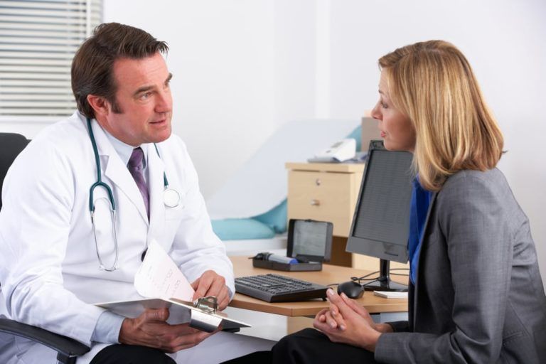 American doctor talking to businesswoman patient